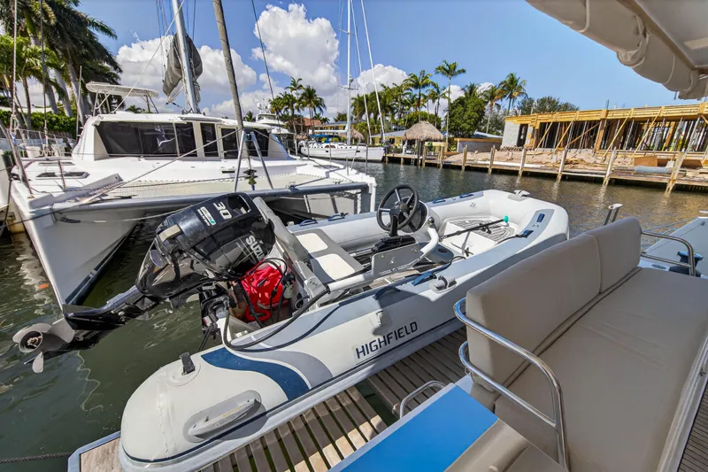 Slide: The Image of 2022 Fountaine Pajot Tanna 47 catamaran docked with inflatable boat, sunny marina setting. - 17