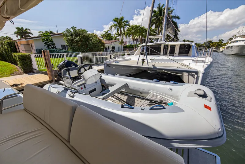 Slide: The Image of 2022 Fountaine Pajot Tanna 47 catamaran docked with inflatable dinghy, surrounded by palm trees. - 18