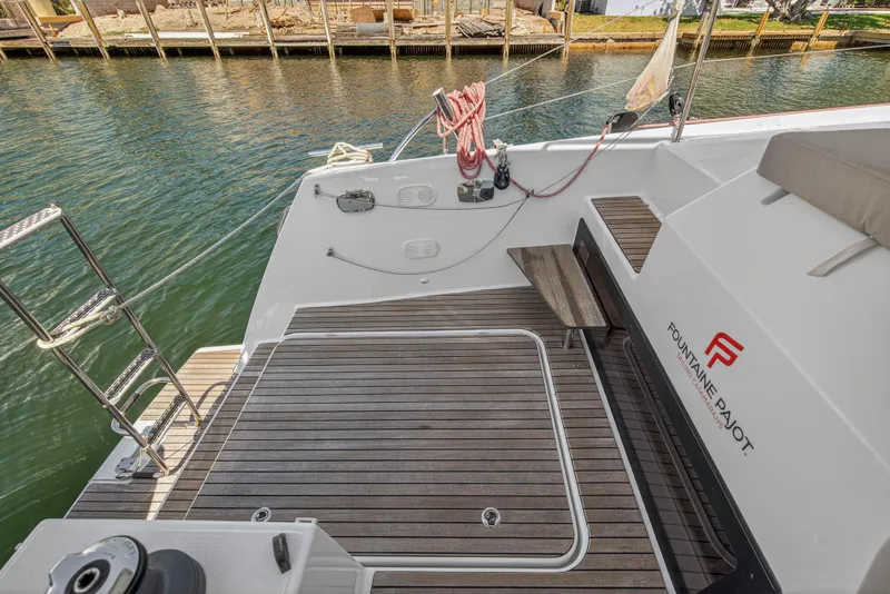 Slide: The Image of 2022 Fountaine Pajot Tanna 47 yacht deck with wooden flooring and water view. - 28