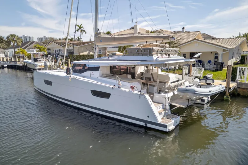 Slide: The Image of 2022 Fountaine Pajot Tanna 47 catamaran docked in a sunny residential marina. - 4