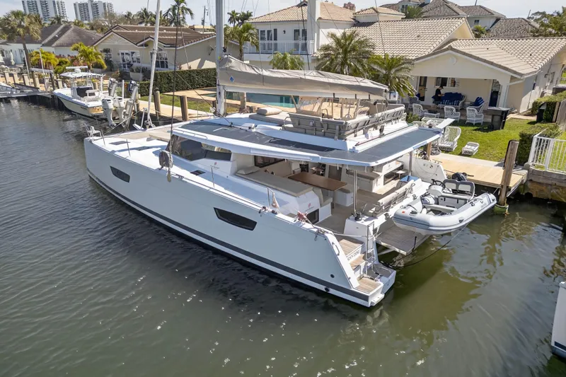 Slide: The Image of 2022 Fountaine Pajot Tanna 47 catamaran docked in a residential marina setting. - 5