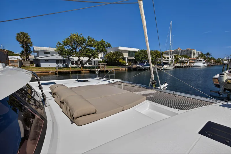 Slide: The Image of 2022 Fountaine Pajot Tanna 47 catamaran docked in a scenic marina setting. - 50