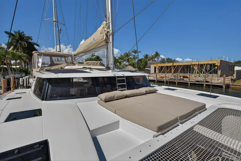 Slide: The Image of 2022 Fountaine Pajot Tanna 47 catamaran docked, featuring spacious deck and sunbathing area. - 52