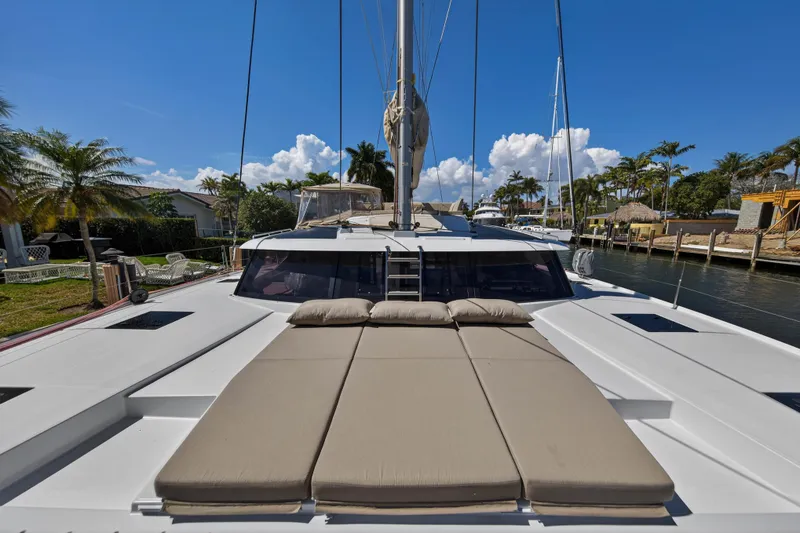Slide: The Image of 2022 Fountaine Pajot Tanna 47 catamaran with sunbathing area, docked by palm trees. - 53