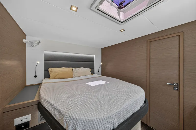 Slide: The Image of Modern bedroom interior on 2022 Fountaine Pajot Tanna 47 yacht, featuring cozy bed and skylight. - 89