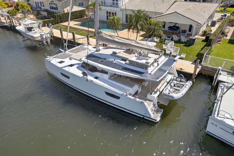 Slide: The Image of 2022 Fountaine Pajot Tanna 47 catamaran docked by waterfront home. - 9