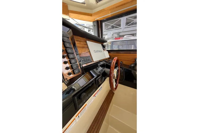 Slide: The Image of 2026 Ranger Tugs R-27 helm with Garmin display and wooden steering wheel. - 12