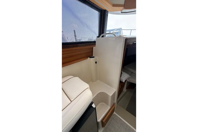 Slide: The Image of 2026 Ranger Tugs R-27 interior with seating and window view. - 23