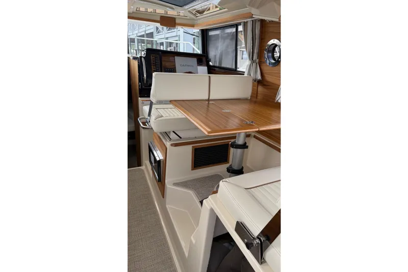 Slide: The Image of Interior of 2026 Ranger Tugs R-27, featuring elegant wood and leather seating. - 24