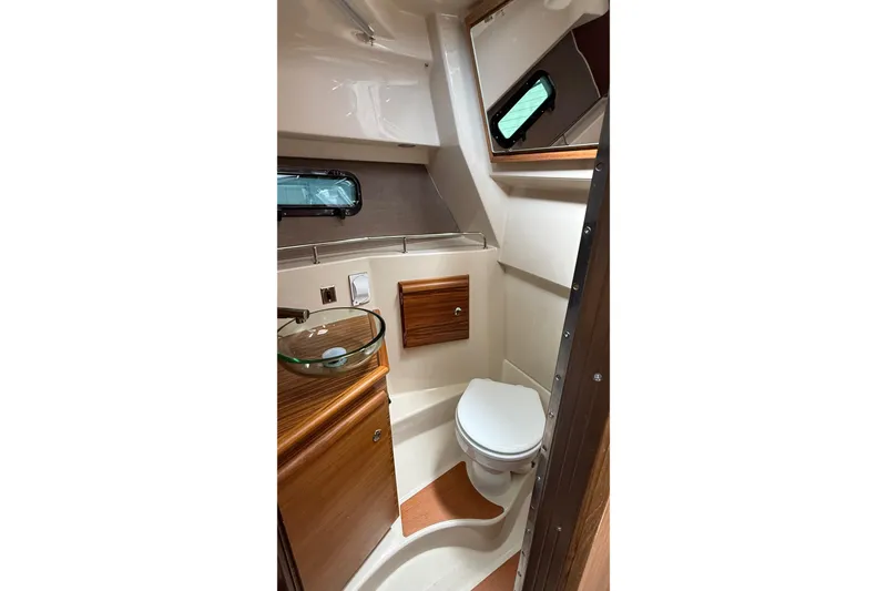 Slide: The Image of 2026 Ranger Tugs R-27 boat bathroom with modern fixtures and wood accents. - 28