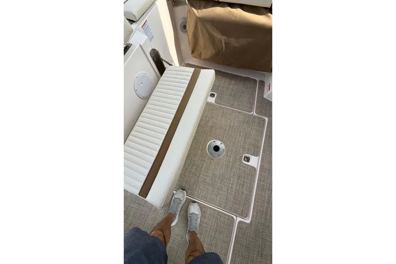 Slide: The Image of 2026 Ranger Tugs R-27 interior with cushioned seating and textured flooring. - 6