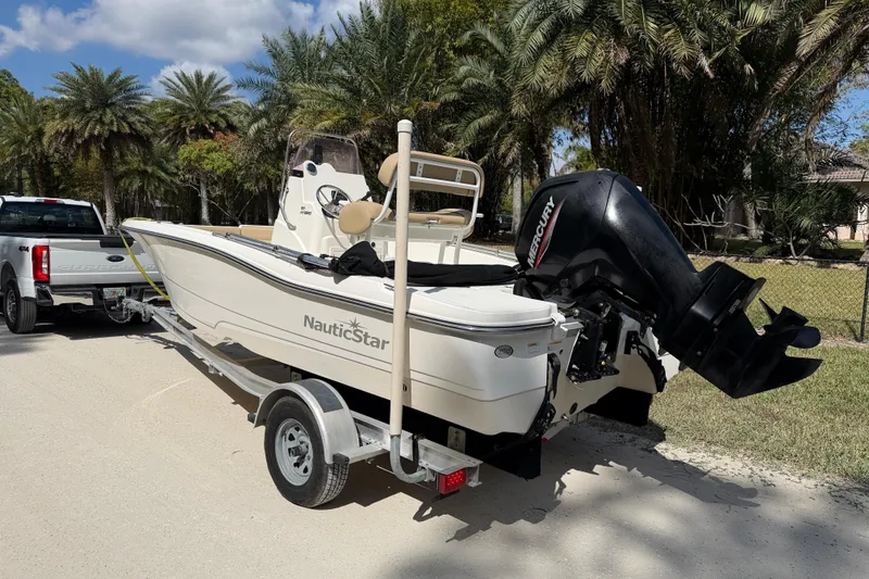 Slide: The Image of 2021 NauticStar 191 Hybrid boat with canopy on display at dealership. - 2