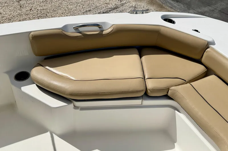 Slide: The Image of 2021 NauticStar 191 Hybrid boat with tan cushioned seating and cup holders. - 22