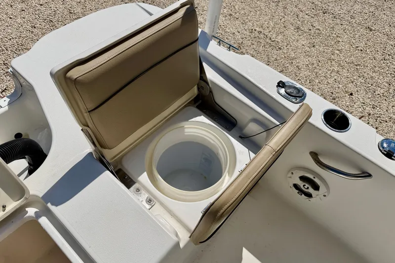 Slide: The Image of 2021 NauticStar 191 Hybrid boat interior with open storage compartment and beige seating. - 26