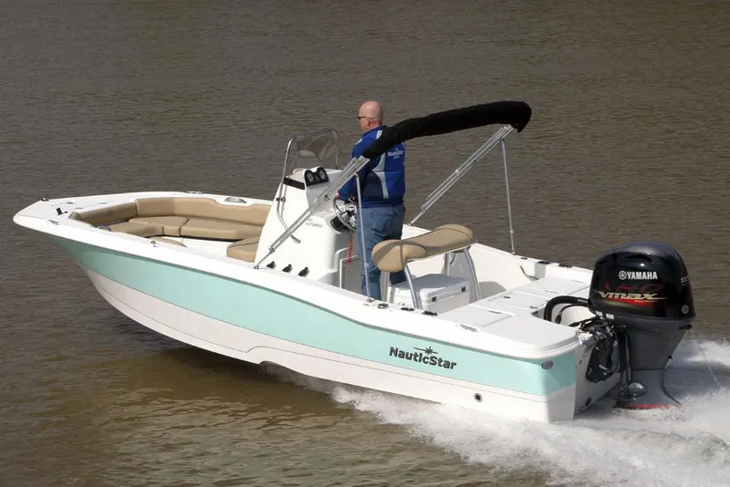 Slide: The Image of 2021 NauticStar 191 Hybrid boat with Mercury 90 engine, parked on gravel. - 6