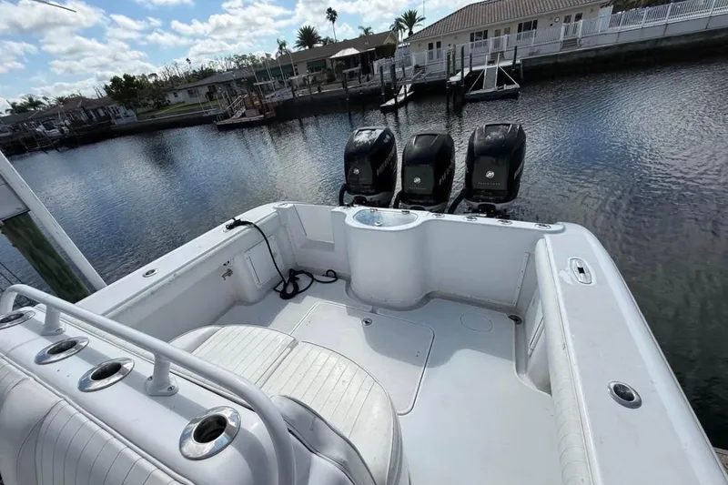 Slide: The Image of 2004 Yellowfin 36 Offshore boat with triple outboard engines docked by waterfront homes. - 10