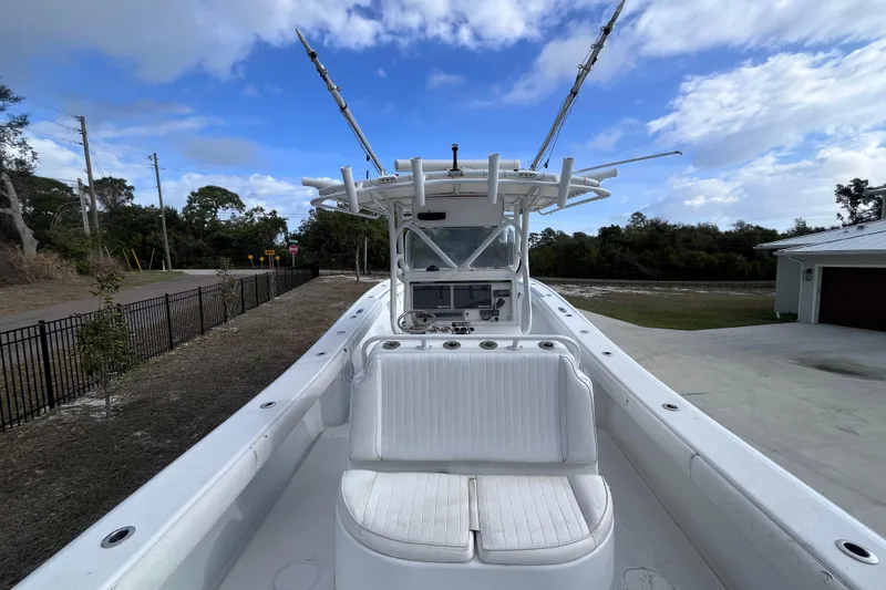 Slide: The Image of 2004 Yellowfin 36 Offshore boat with white seating and fishing rod holders under a blue sky. - 11