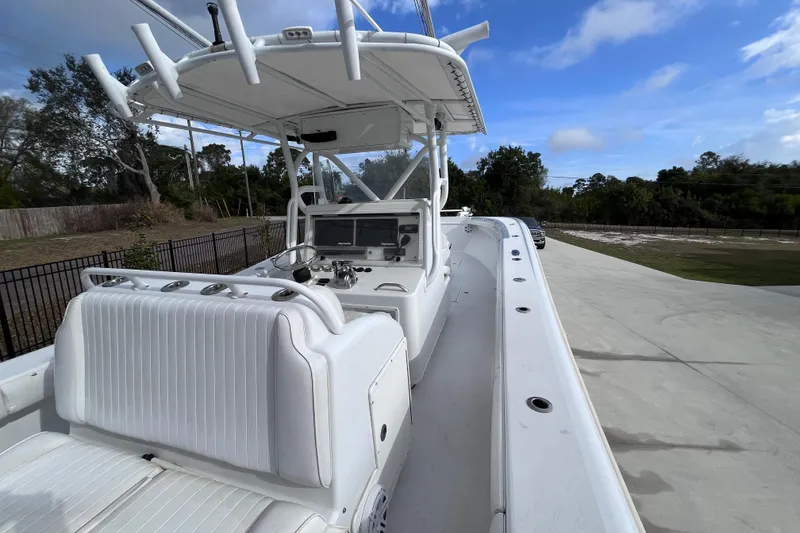 Slide: The Image of 2004 Yellowfin 36 Offshore boat with white seating and console, parked outdoors. - 12