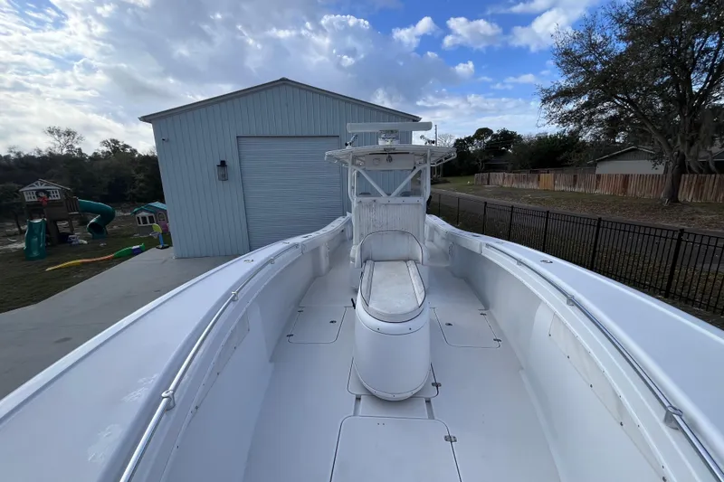 Slide: The Image of 2004 Yellowfin 36 Offshore boat docked near a blue storage building under a cloudy sky. - 21