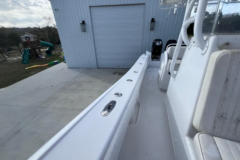 Slide: The Image of 2004 Yellowfin 36 Offshore boat docked near a garage with playground in background. - 25