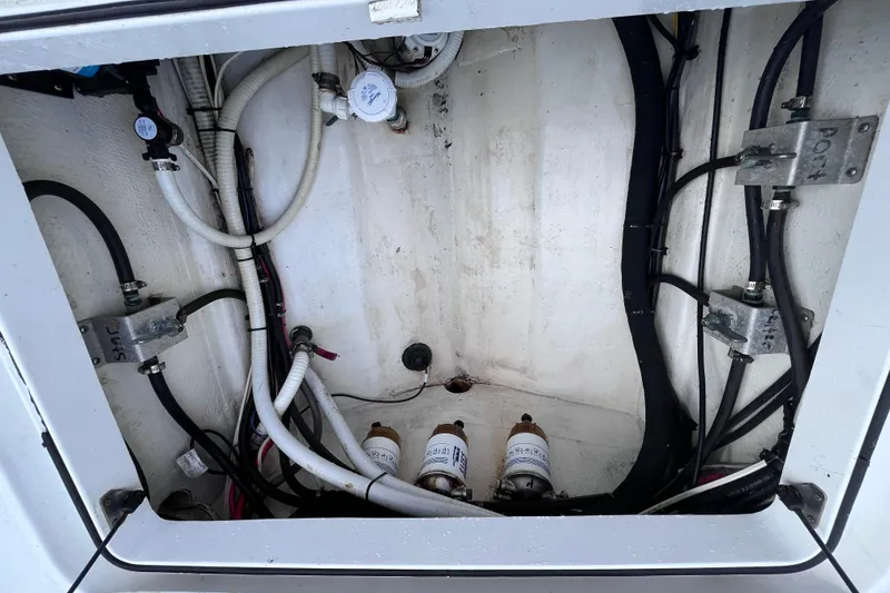 Slide: The Image of 2004 Yellowfin 36 Offshore boat compartment with wiring and filters. - 37