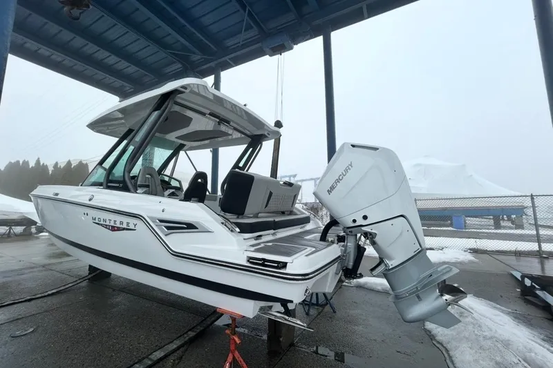 Slide: The Image of 2026 Monterey Elite 27 OB boat with Mercury outboard engine in a snowy setting. - 2