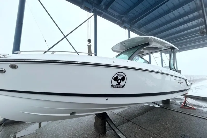 Slide: The Image of 2026 Monterey Elite 27 OB boat under a blue canopy, showcasing sleek design and award sticker. - 3