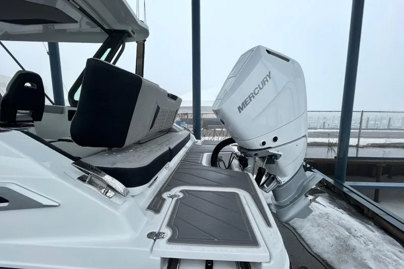 Slide: The Image of 2026 Monterey Elite 27 OB boat with Mercury outboard motor, docked in snowy conditions. - 4
