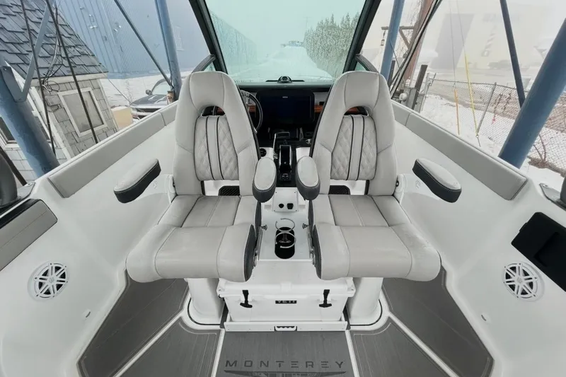 Slide: The Image of 2026 Monterey Elite 27 OB boat interior with dual captain's chairs and modern dashboard. - 7