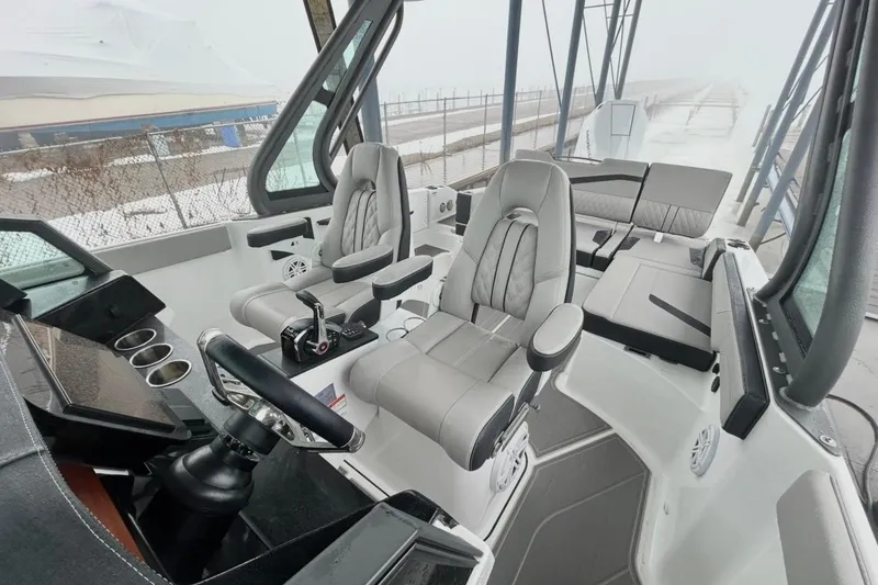 Slide: The Image of 2026 Monterey Elite 27 OB boat interior with modern seating and steering console. - 9