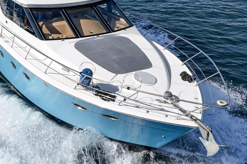 Slide: The Image of 2003 Carver 570 Voyager Pilothouse cruising on open water, showcasing sleek design and blue hull. - 11