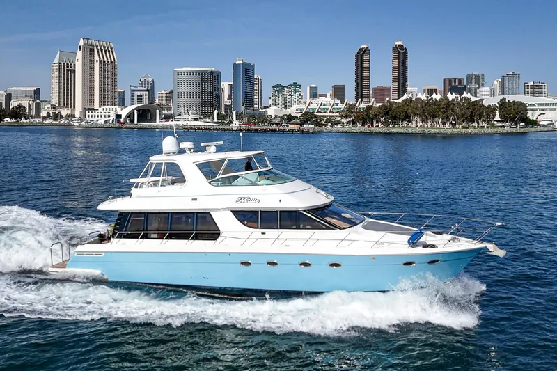 Slide: The Image of 2003 Carver 570 Voyager Pilothouse yacht cruising near city skyline. - 3