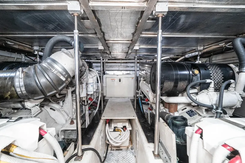 Slide: The Image of Engine room of 2003 Carver 570 Voyager Pilothouse, showcasing mechanical components and piping. - 38