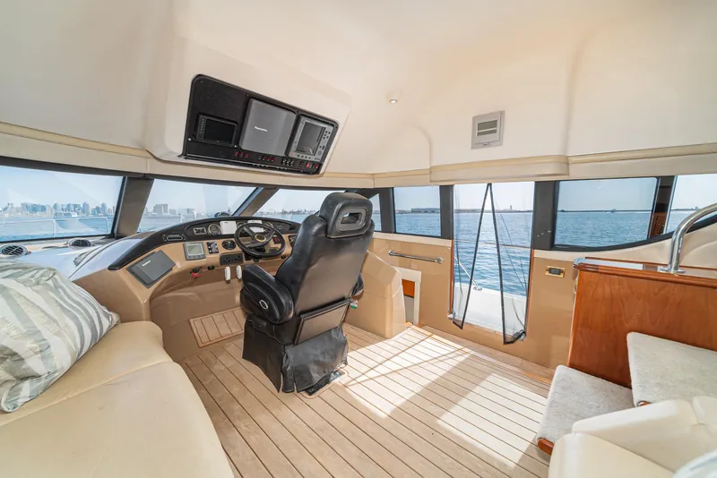 Slide: The Image of 2003 Carver 570 Voyager Pilothouse interior with helm, leather seating, and panoramic windows. - 43