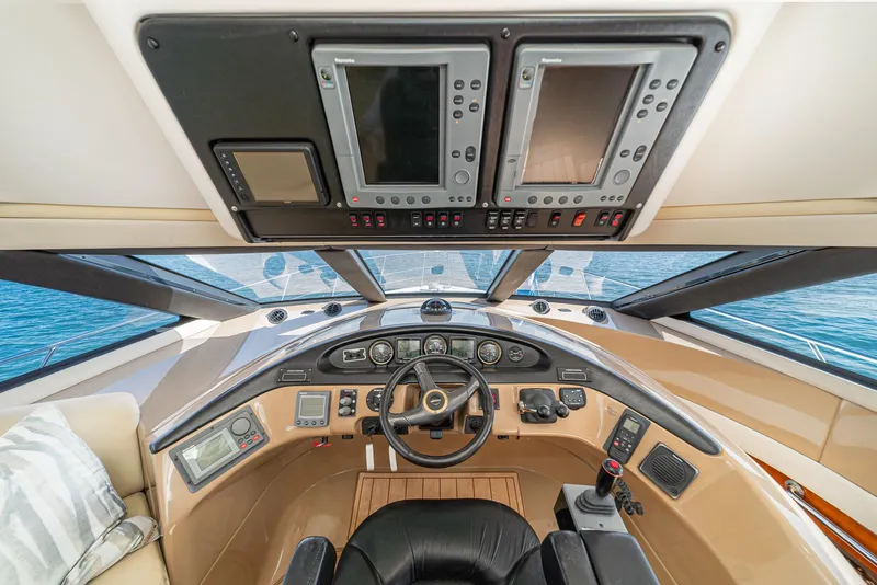 Slide: The Image of Pilothouse interior of 2003 Carver 570 Voyager, featuring navigation controls and panoramic windows. - 48