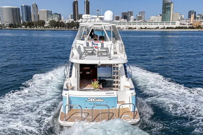Slide: The Image of 2003 Carver 570 Voyager Pilothouse yacht cruising near city skyline. - 22