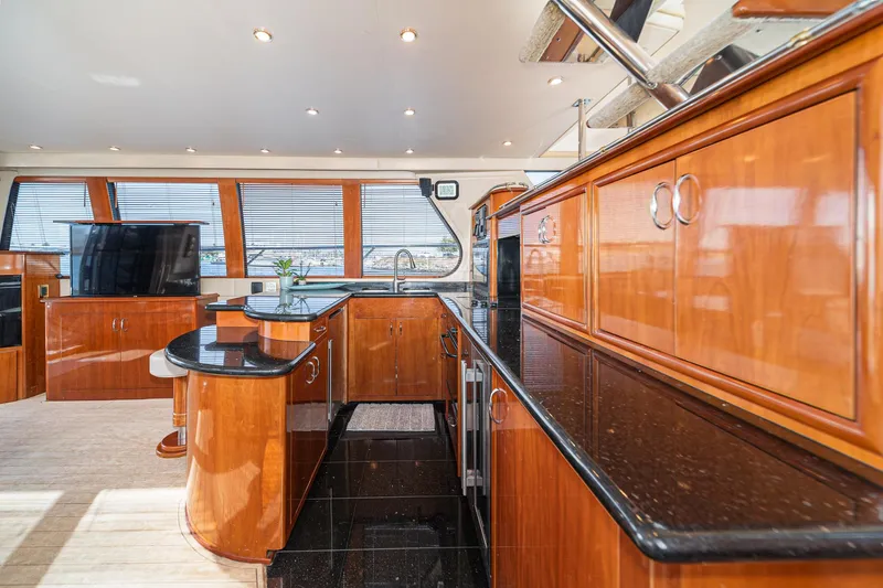 Slide: The Image of Luxurious 2003 Carver 570 Voyager Pilothouse interior with sleek wood cabinetry and modern amenities. - 37