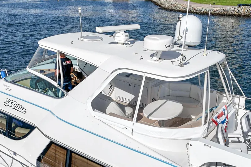 Slide: The Image of 2003 Carver 570 Voyager Pilothouse yacht on water, featuring spacious deck and modern navigation equipment. - 7