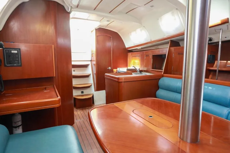Slide: The Image of Interior of 2006 Beneteau 343 sailboat with wood finish and blue seating. - 12