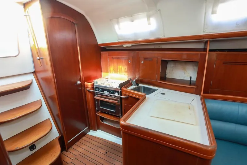 Slide: The Image of Interior of 2006 Beneteau 343 sailboat with wooden cabinetry and compact kitchen area. - 15