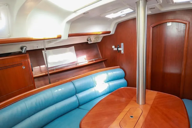 Slide: The Image of Interior of 2006 Beneteau 343 sailboat with blue seating and wooden finishes. - 17