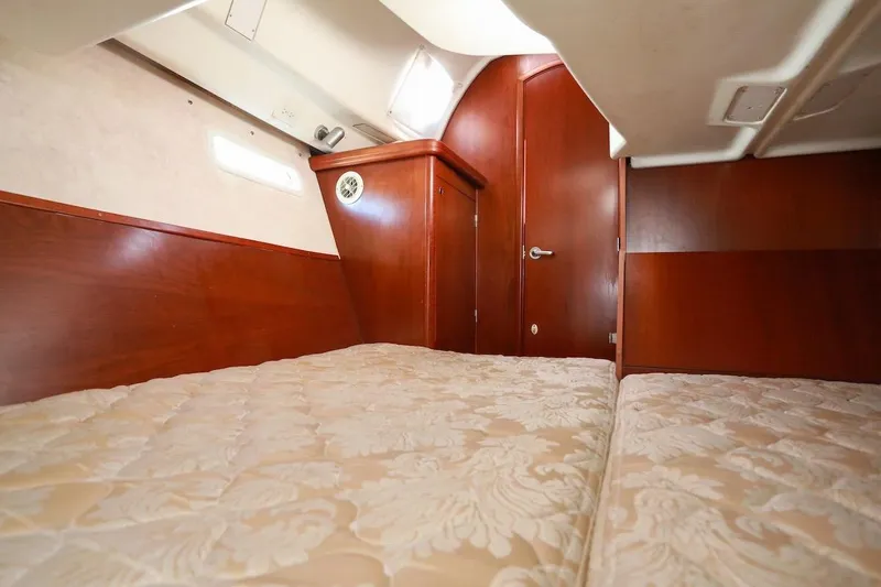 Slide: The Image of Interior cabin of 2006 Beneteau 343 sailboat with wood paneling and cozy bedding. - 20