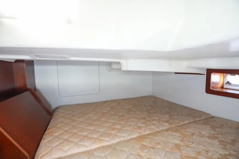 Slide: The Image of 2006 Beneteau 343 cabin interior with cozy bed and wooden accents. - 22
