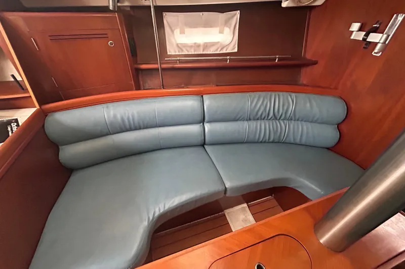 Slide: The Image of Interior of 2006 Beneteau 343 sailboat with blue cushioned seating and wooden finish. - 3