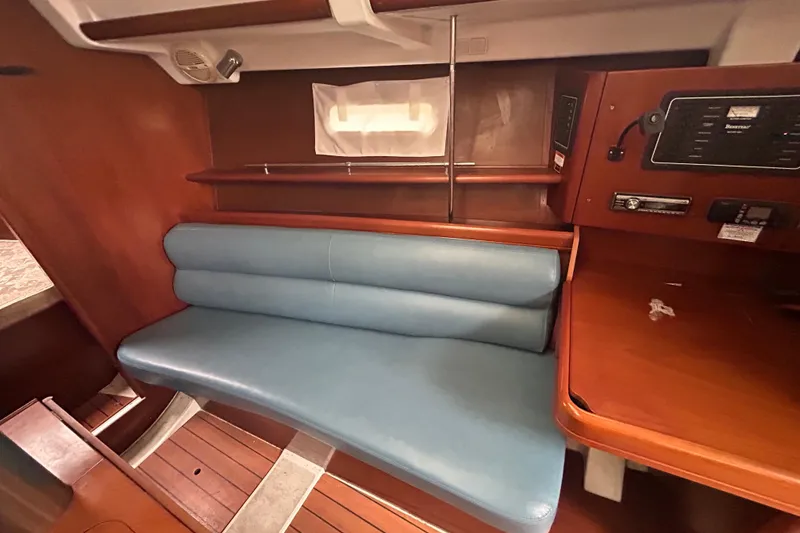 Slide: The Image of 2006 Beneteau 343 yacht interior with blue seating and wooden cabinetry. - 37