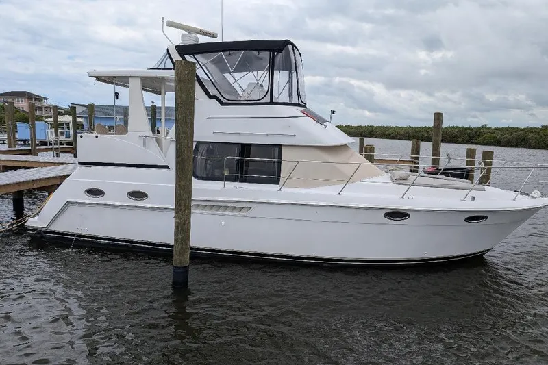 Slide: The Image of 2003 Carver 356 Motor Yacht docked at a marina under cloudy skies. - 0
