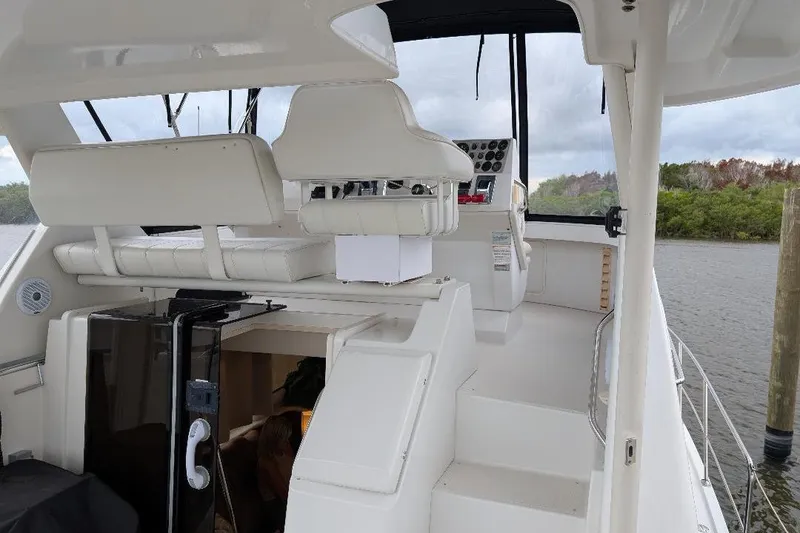 Slide: The Image of 2003 Carver 356 Motor Yacht interior with helm, white seating, and water view. - 10