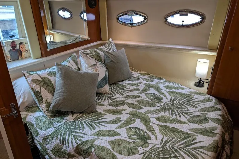 Slide: The Image of Cozy bedroom in 2003 Carver 356 Motor Yacht with tropical bedding and porthole windows. - 24