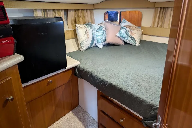 Slide: The Image of Cozy bedroom in 2003 Carver 356 Motor Yacht with bed, pillows, and mini fridge. - 27