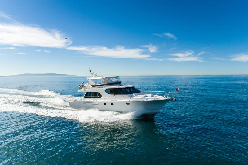 Slide: The Image of Luxurious 2006 West Bay 64 yacht cruising on open blue sea under clear skies. - 10